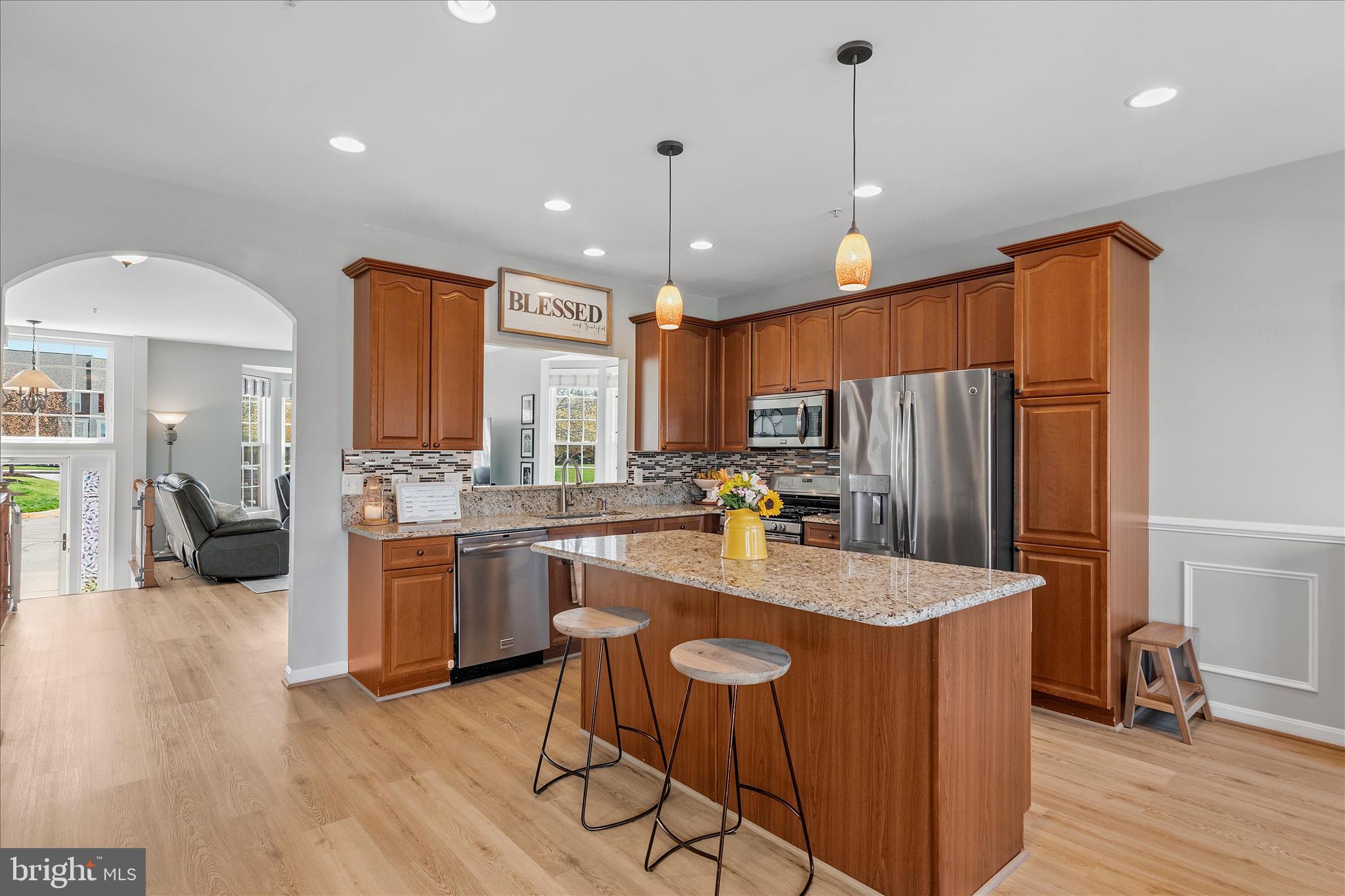 4840 Marsden Place Frederick, MD 21703 - Photo 13 of 46 a kitchen with stainless steel appliances granite countertop a refrigerator a sink dishwasher a oven and a dining table with wooden floor
