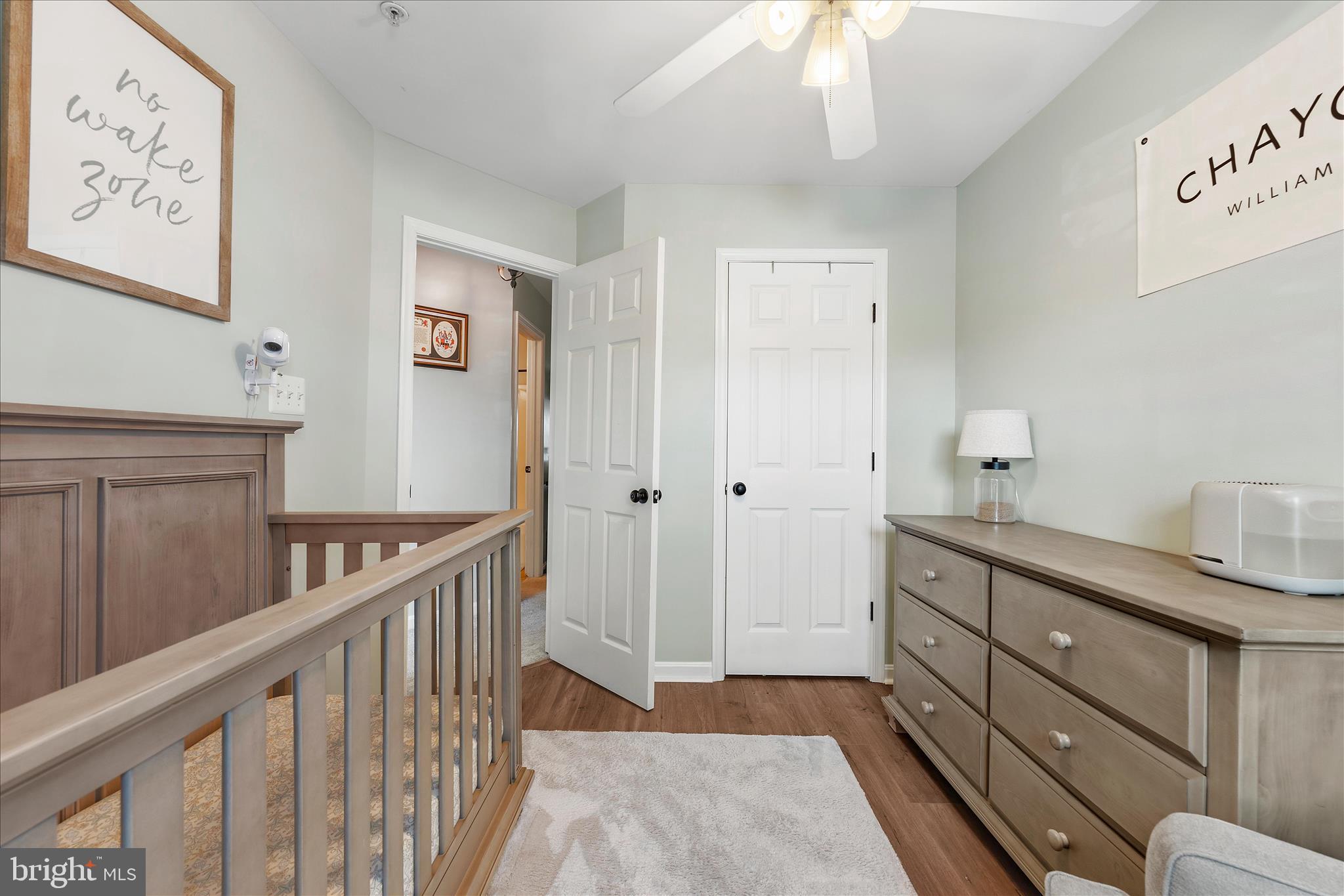 4840 Marsden Place Frederick, MD 21703 - Photo 23 of 46 a view of a hallway to a livingroom with wooden floor and furniture