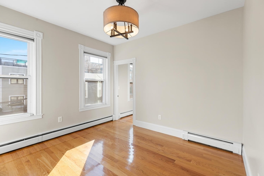 6-8 School Street Boston, MA 02129 - Photo 7 of 27 a view of an empty room with window and wooden floor