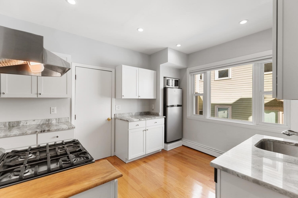 6-8 School Street Boston, MA 02129 - Photo 9 of 27 a kitchen with stainless steel appliances granite countertop a sink stove and refrigerator
