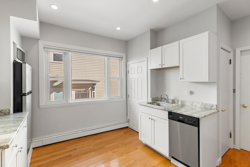 6-8 School Street Boston, MA 02129 - Photo 10 of 27 a kitchen with stainless steel appliances granite countertop a sink stove and cabinets