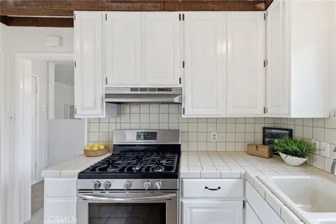 a kitchen with white cabinets and appliances