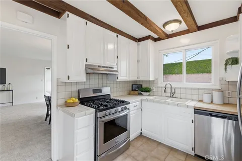 a kitchen with stainless steel appliances granite countertop a sink stove cabinets and a refrigerator