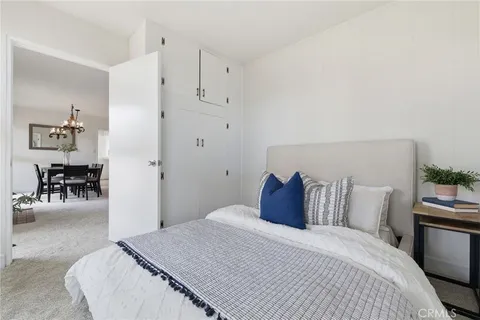 a bedroom with a bed and table chair