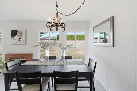 a view of a dining room with furniture a chandelier and wooden floor