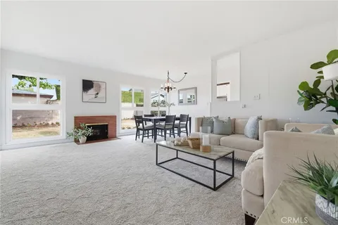a living room with furniture a fireplace and a potted plant