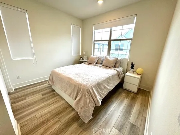 a view of a hallway with wooden floor and a bathroom