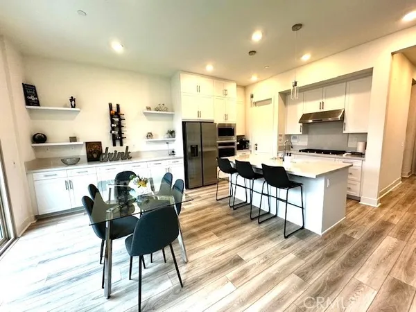 a kitchen with refrigerator and chairs