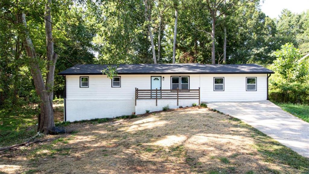 a view of a house with a yard and large tree
