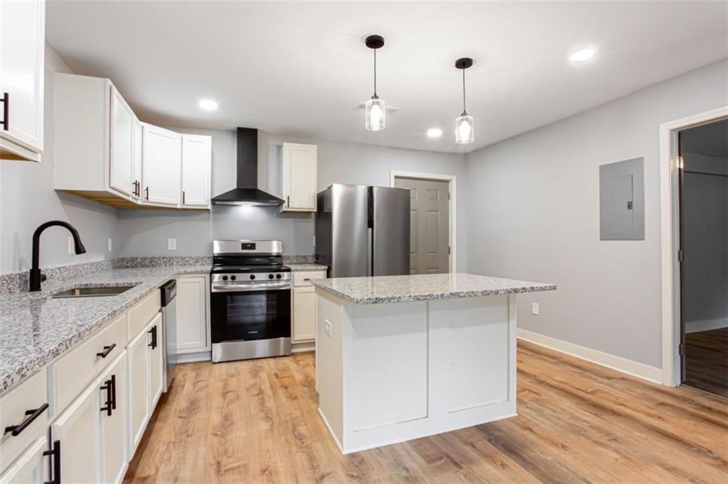 3652 Sweetbriar Circle Lithia Springs, GA 30122 - Photo 14 of 30 a kitchen with stainless steel appliances granite countertop a sink stove a refrigerator and a oven with wooden floor