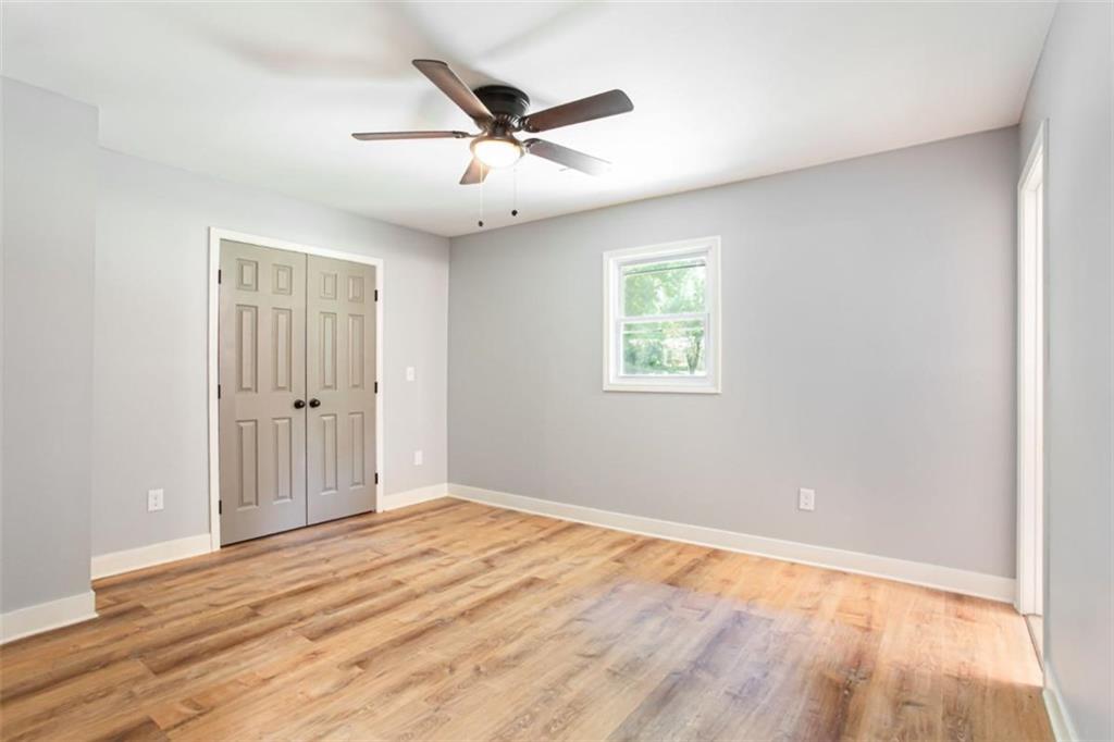 3652 Sweetbriar Circle Lithia Springs, GA 30122 - Photo 18 of 30 an empty room with wooden floor ceiling fan and windows