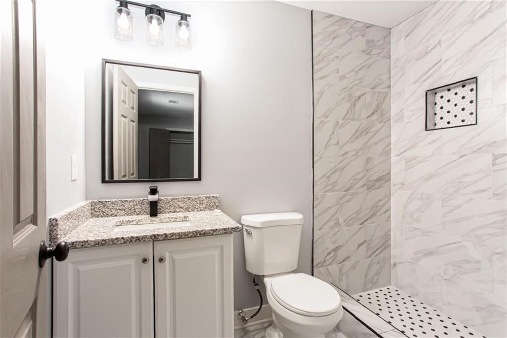 3652 Sweetbriar Circle Lithia Springs, GA 30122 - Photo 21 of 30 a bathroom with a granite countertop toilet sink and mirror