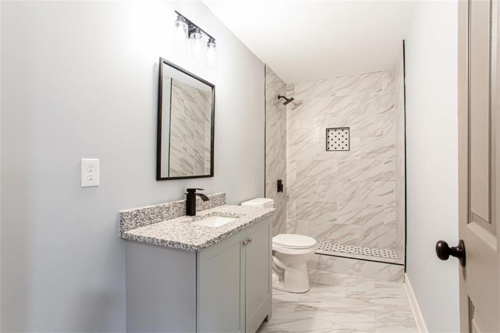 3652 Sweetbriar Circle Lithia Springs, GA 30122 - Photo 26 of 30 a bathroom with a granite countertop sink toilet and mirror