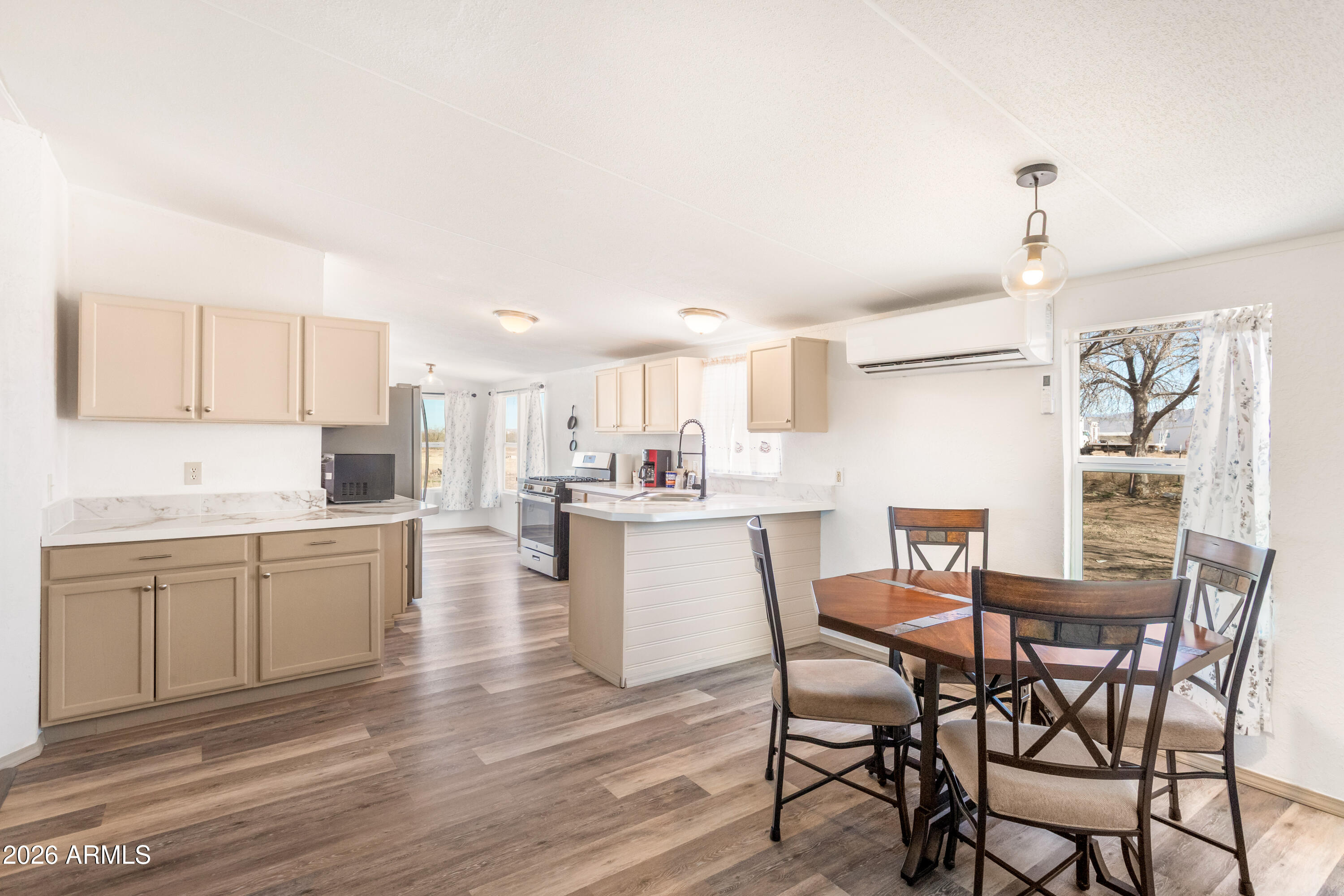 10405 North Mormon Road Elfrida, AZ 85610 - Photo 11 of 43 a kitchen with a table chairs microwave and cabinets