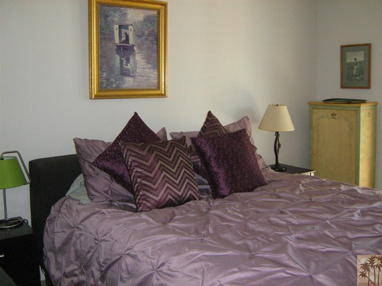 58 Majorca Drive Rancho Mirage, CA 92270 - Photo 13 of 22 a large bed sitting in a bedroom next to a painting on the wall