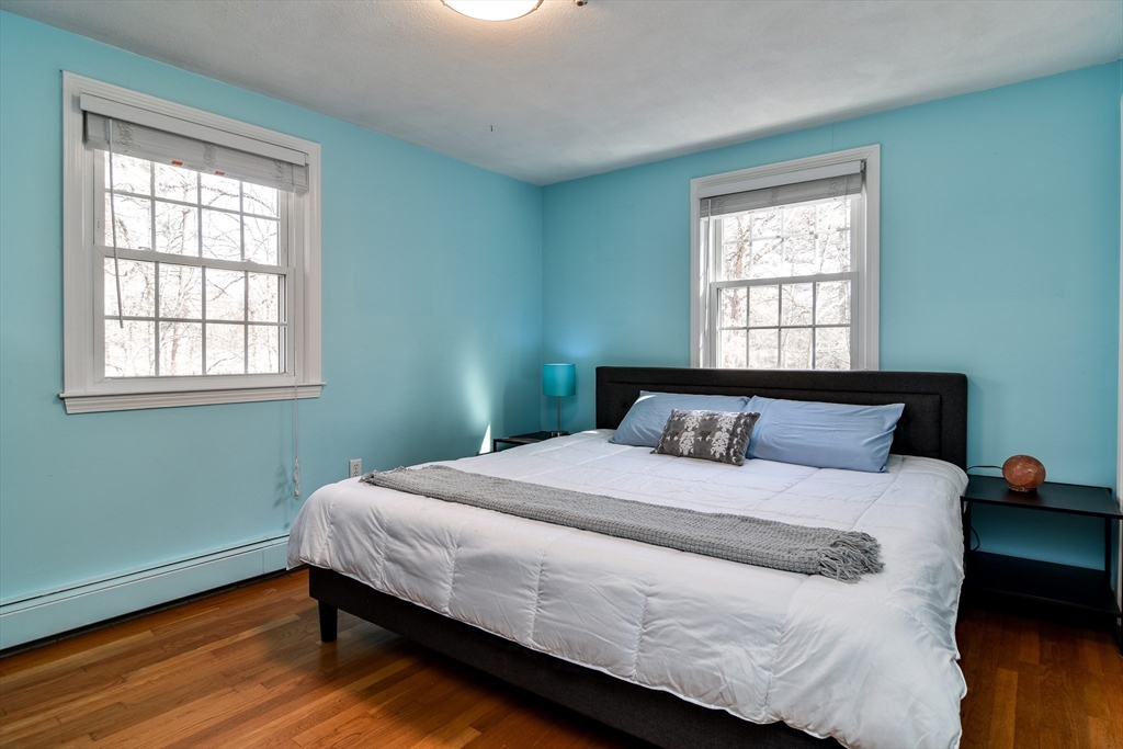 248 Liberty Square Road Boxborough, MA 01719 - Photo 19 of 31 a bedroom with a bed window and wooden floor