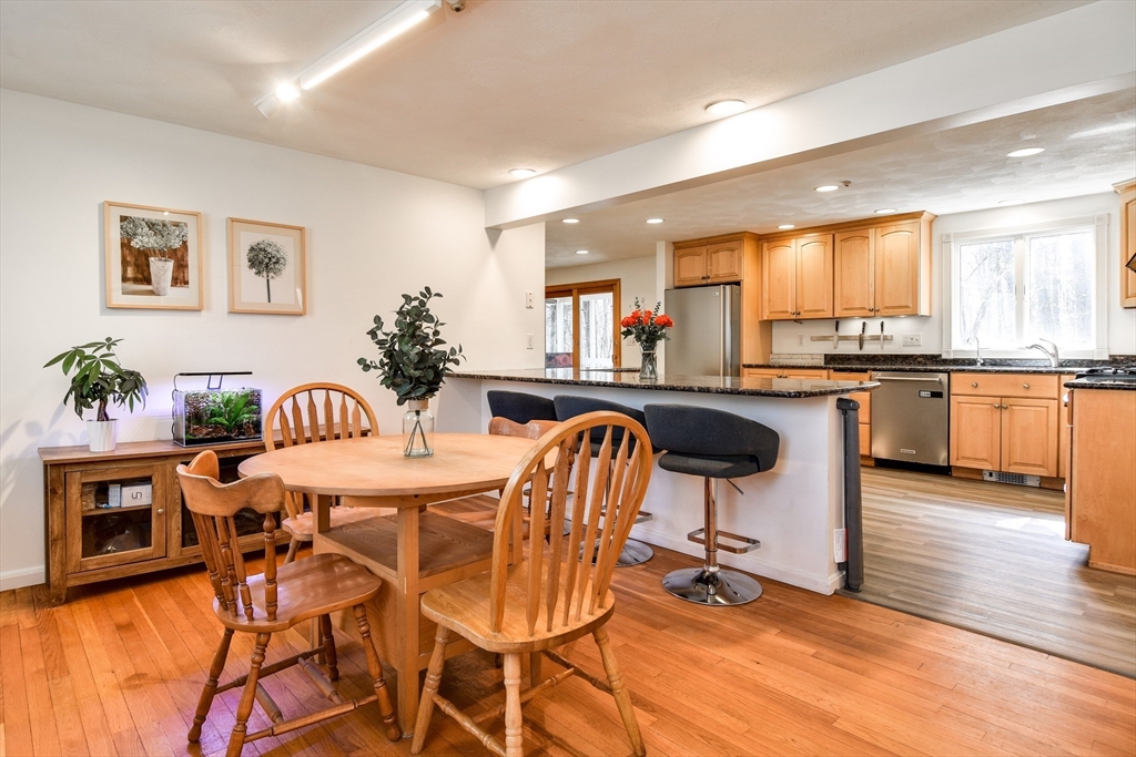 248 Liberty Square Road Boxborough, MA 01719 - Photo 8 of 31 a kitchen with stainless steel appliances granite countertop a stove a sink a microwave dining table and chairs