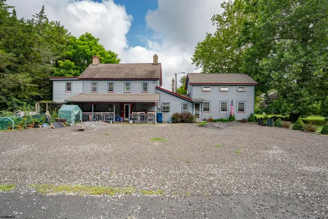 a view of a house with a yard and large tree