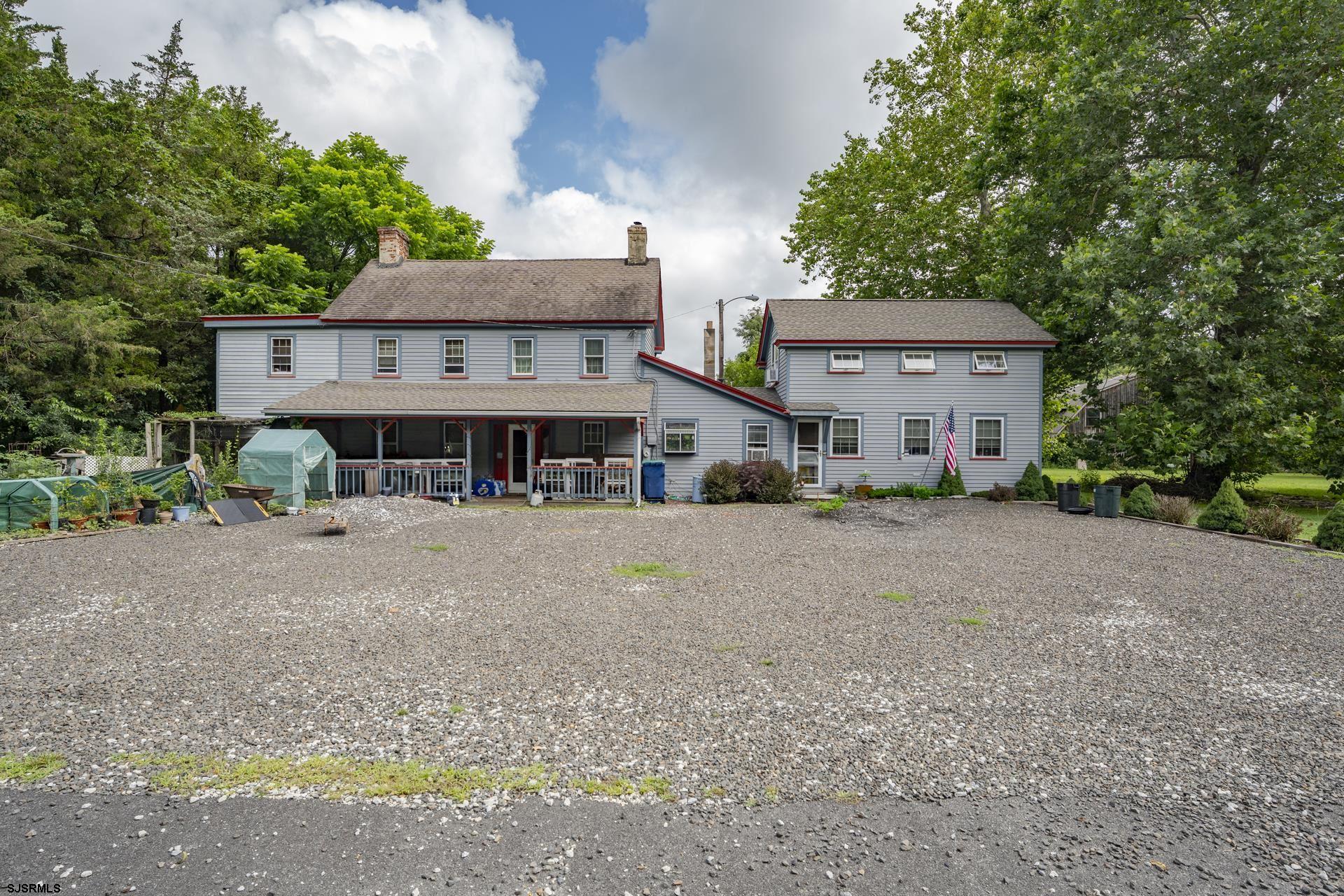 a view of a house with a yard and large tree