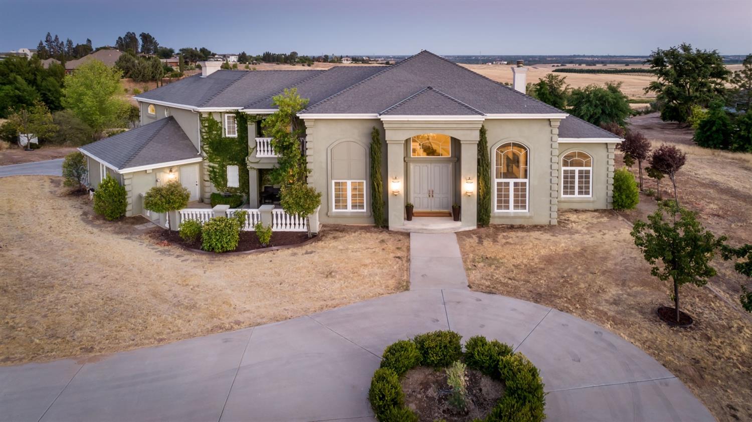 14374 Killarney Drive Madera, CA 93636 - Photo 3 of 56 a front view of a house with a yard and potted plants