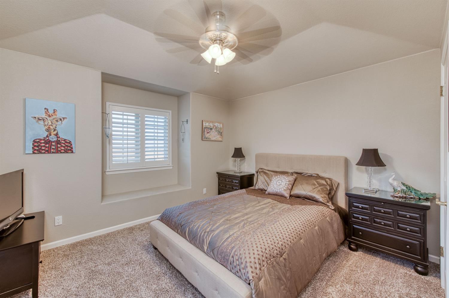 14374 Killarney Drive Madera, CA 93636 - Photo 43 of 56 a bedroom with a bed and a chandelier