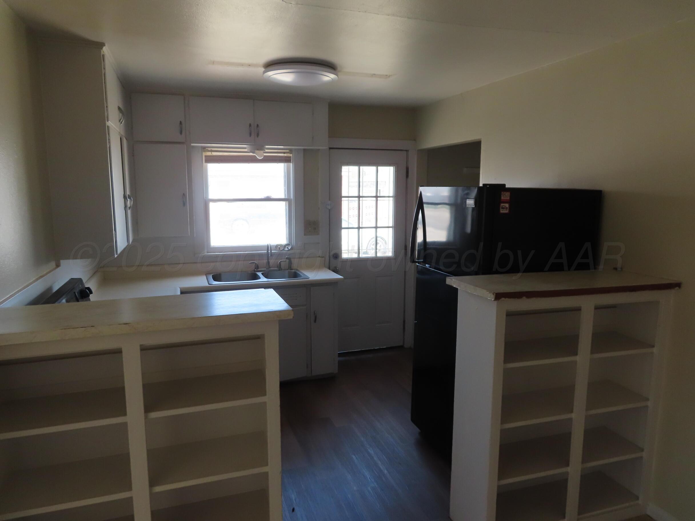 3813 South Washington Street Amarillo, TX 79110 - Photo 6 of 12 a kitchen with a sink cabinets and wooden floor
