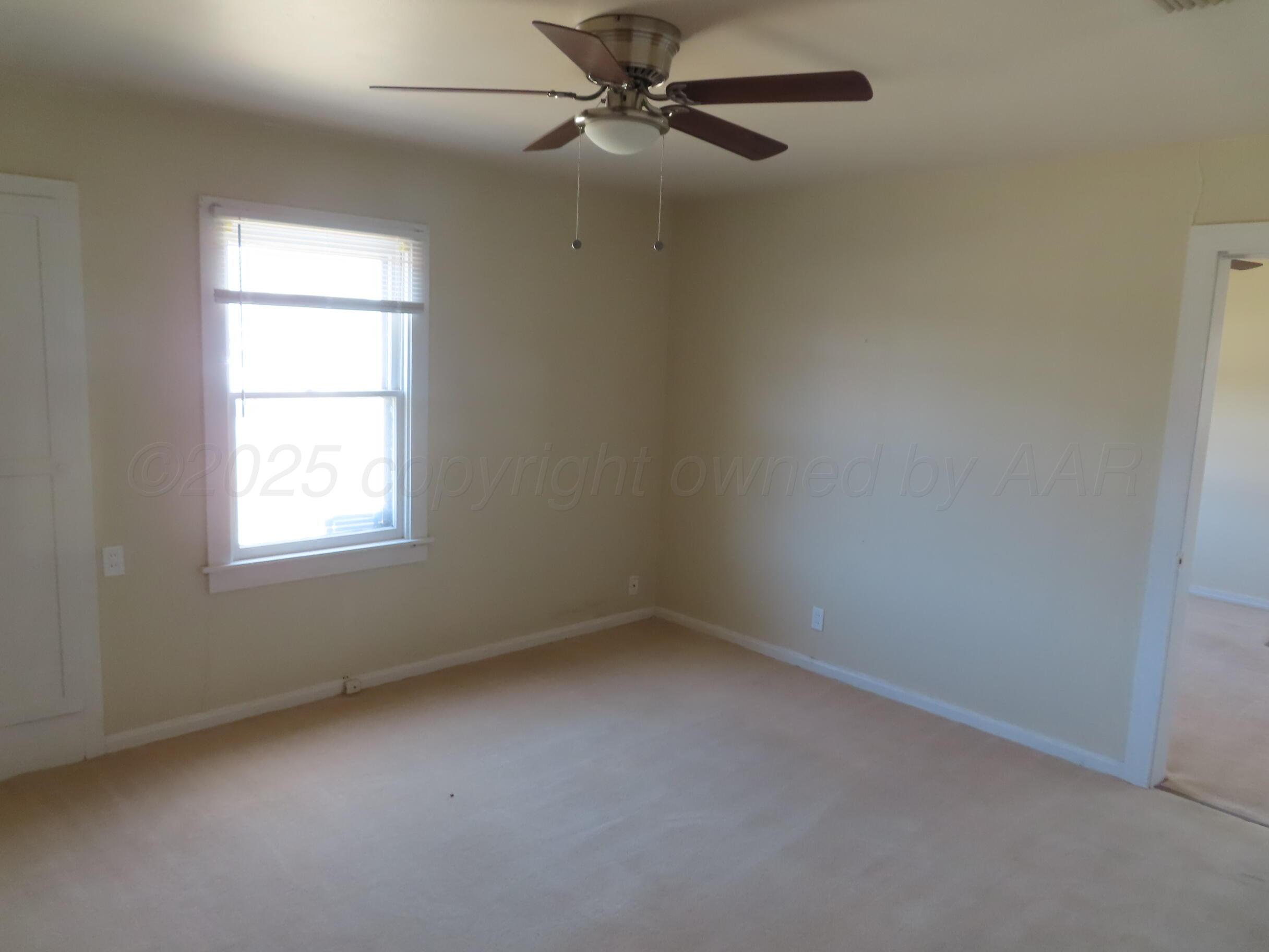 3813 South Washington Street Amarillo, TX 79110 - Photo 7 of 12 an empty room with a window and a fan
