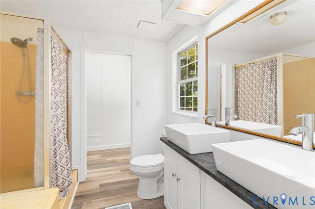 a bathroom with a sink a toilet and shower