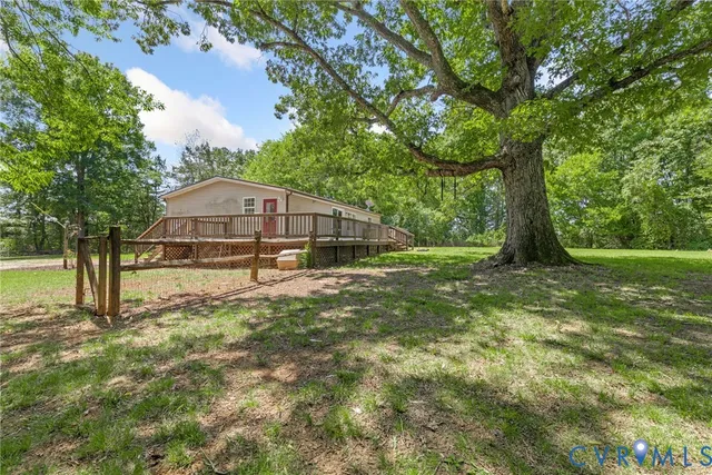 a view of a house with backyard and trees