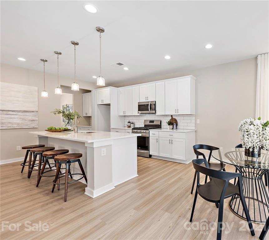 115 Cranford Drive Pineville, NC 28134 - Photo 2 of 7 a kitchen with kitchen island white cabinets and stainless steel appliances