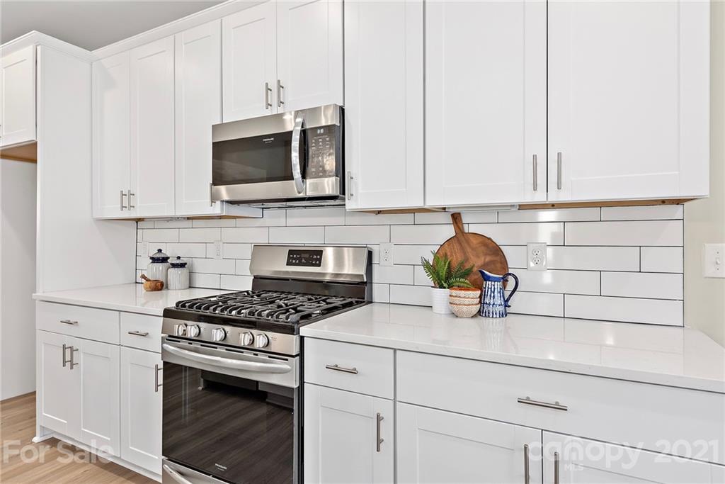 115 Cranford Drive Pineville, NC 28134 - Photo 3 of 7 a kitchen with stainless steel appliances a stove a microwave and cabinets