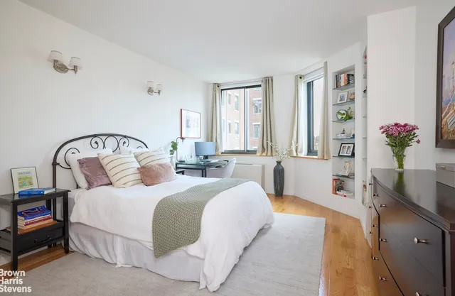 a bedroom with double bed windows and a potted plant