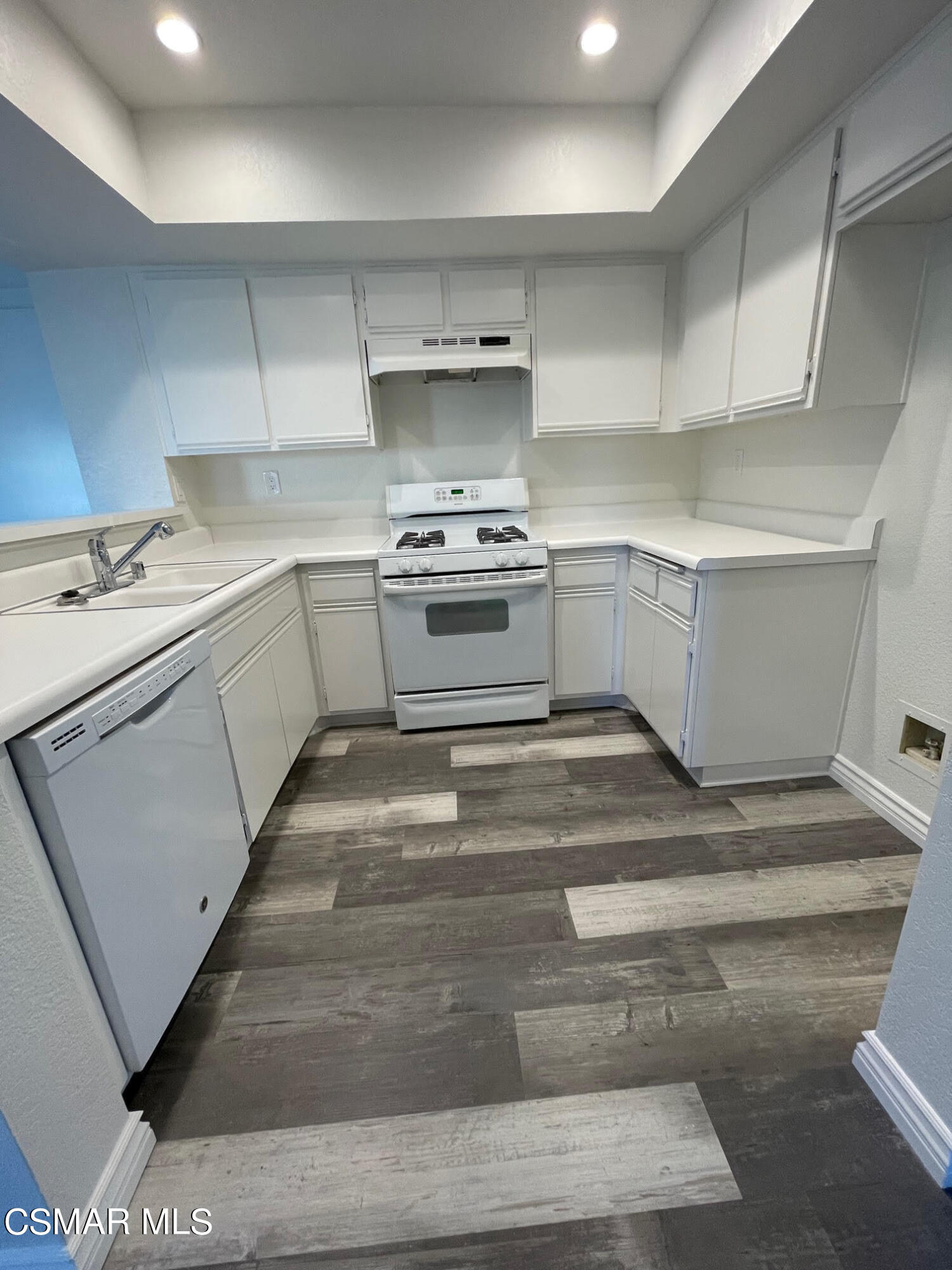 1007 Waltham Road, Unit D Simi Valley, CA 93065 - Photo 8 of 17 a kitchen with a stove and white cabinets