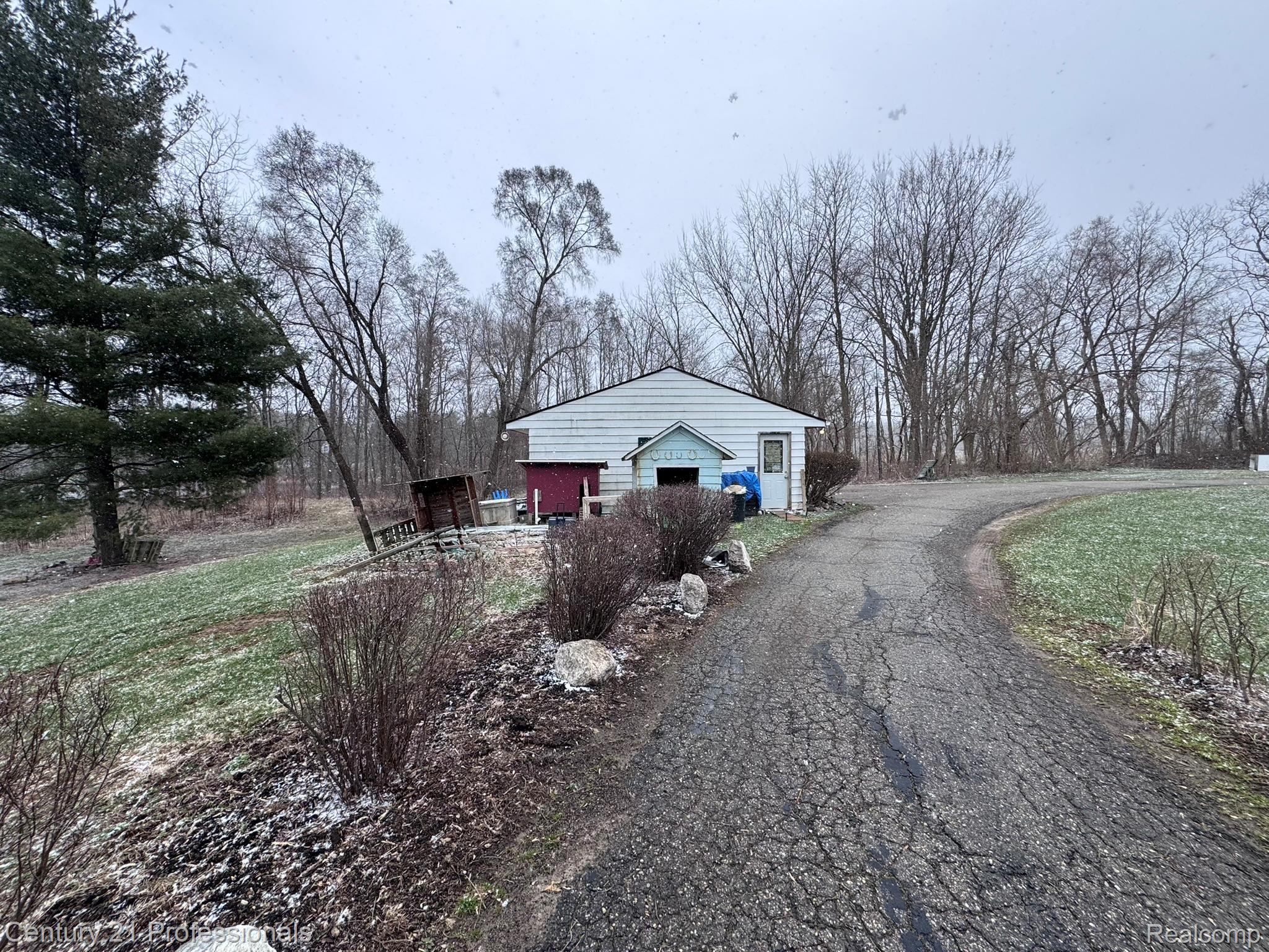 2021 West Rose Center Road Holly, MI 48442 - Photo 8 of 30 View of property exterior featuring a lawn, an outbuilding, view of scattered trees, and asphalt driveway