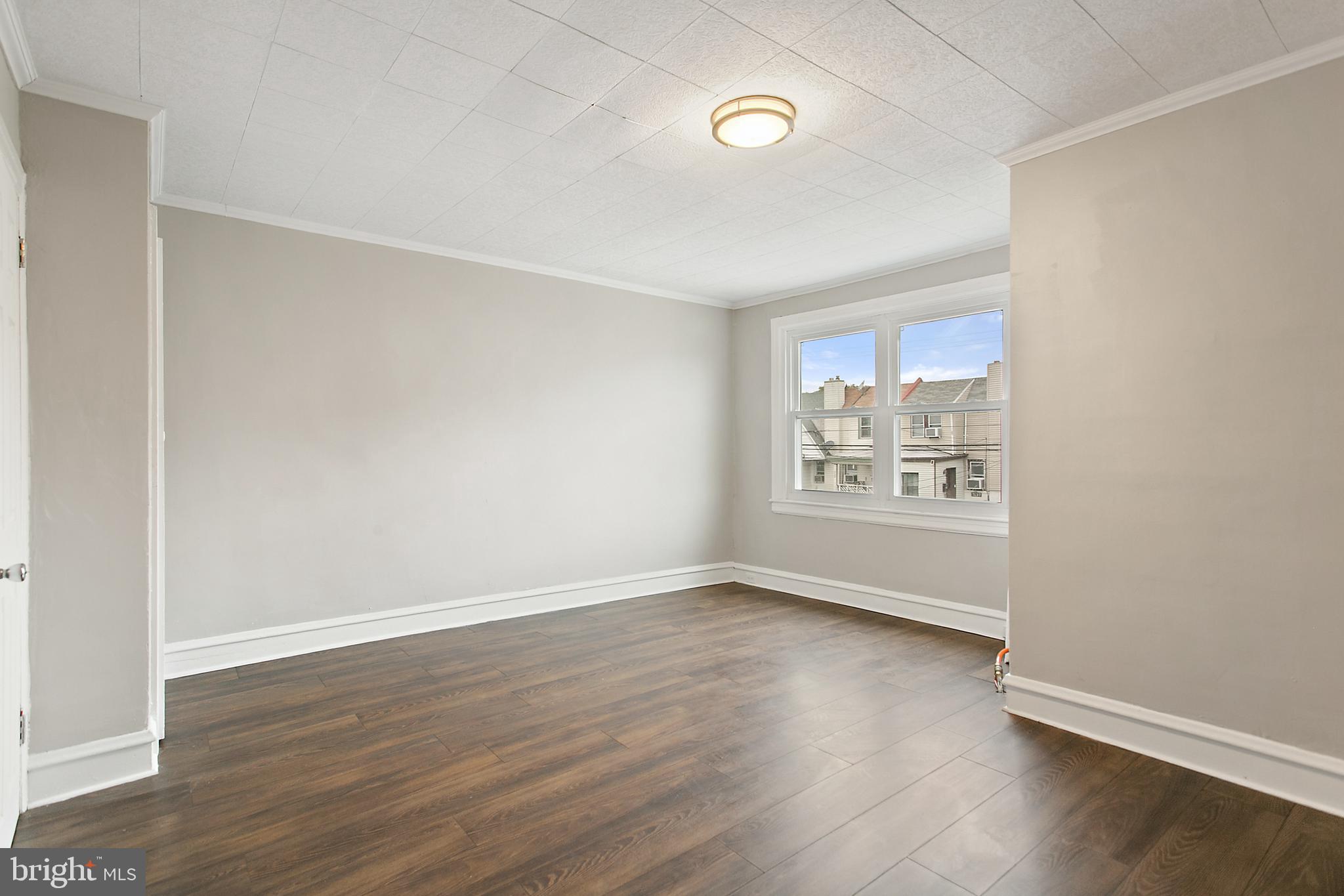 7158 Radbourne Road Upper Darby, PA 19082 - Photo 10 of 15 an empty room with wooden floor and windows