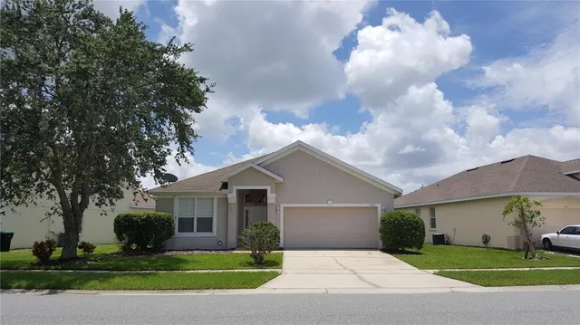 a front view of a house with yard and green space