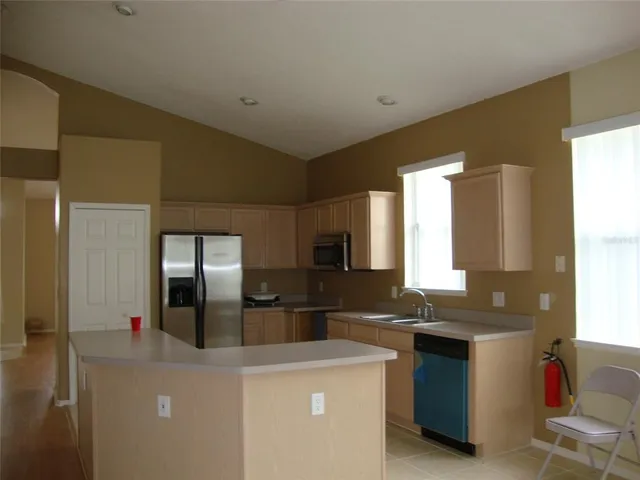 a kitchen with granite countertop a refrigerator and a stove top oven