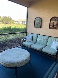 13737 Messina Loop, Unit 101 Bradenton, FL 34211 - Photo 22 of 25 a living room with couch and a floor to ceiling window