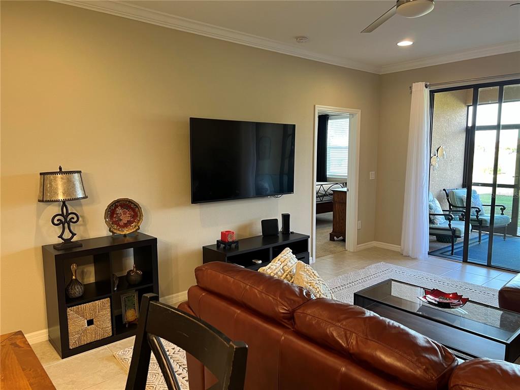 13737 Messina Loop, Unit 101 Bradenton, FL 34211 - Photo 10 of 25 a living room with furniture and a flat screen tv