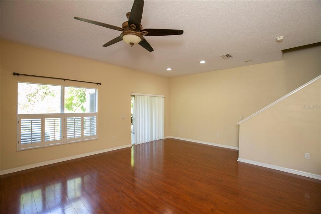 11919 Essington Street New Port Richey, FL 34654 - Photo 8 of 46 a view of an empty room with a window and wooden floor