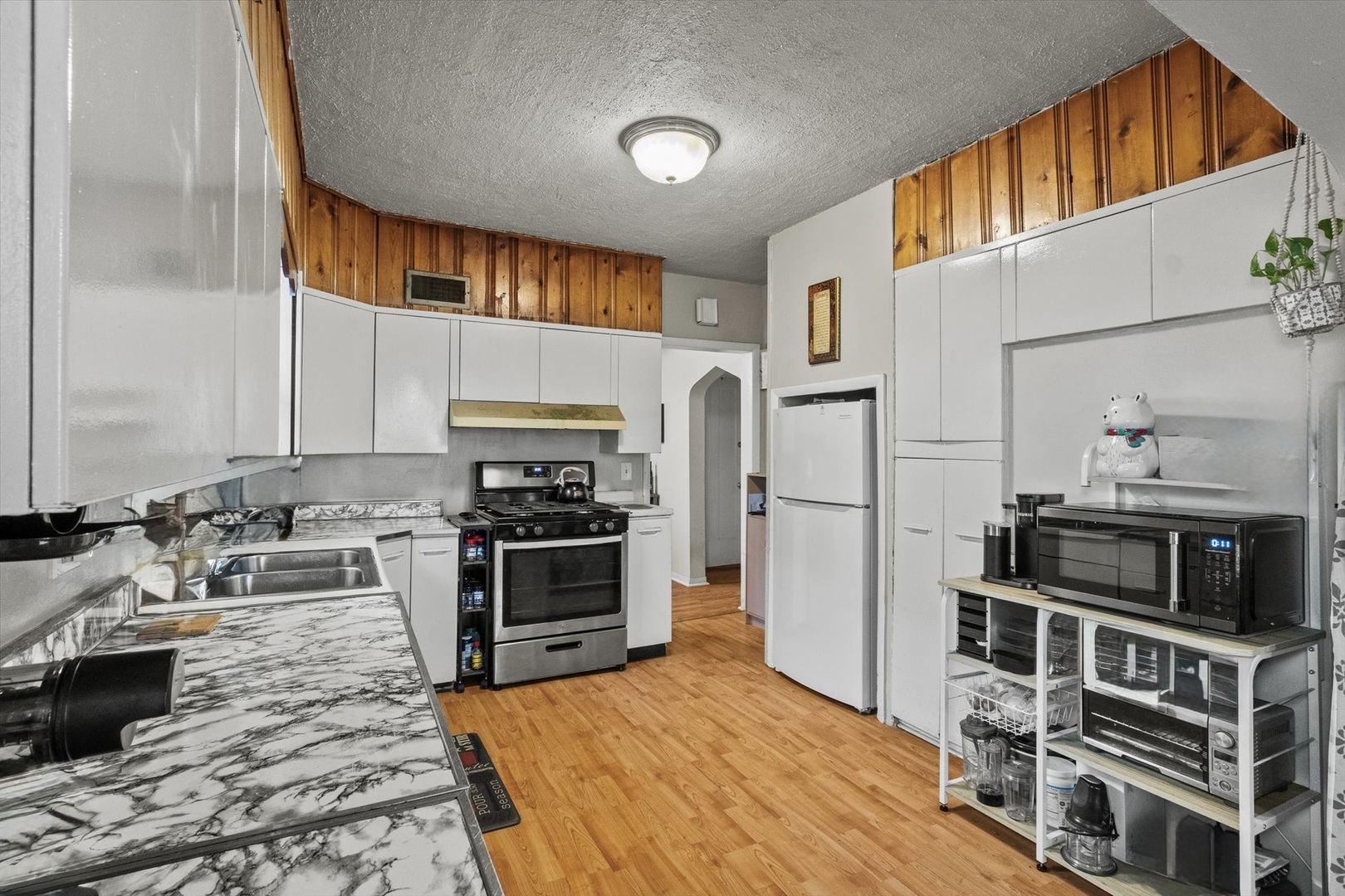 4820 West Haddon Avenue Chicago, IL 60651 - Photo 7 of 27 a kitchen with stainless steel appliances a stove a sink and a refrigerator