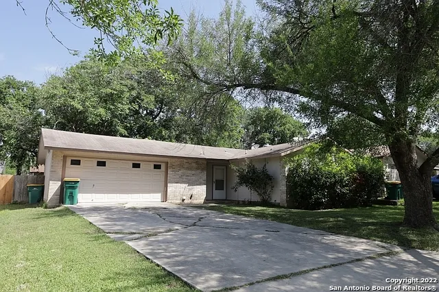 a view of a white house with a yard and large tree