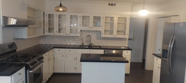 a kitchen with stainless steel appliances granite countertop a stove and a refrigerator