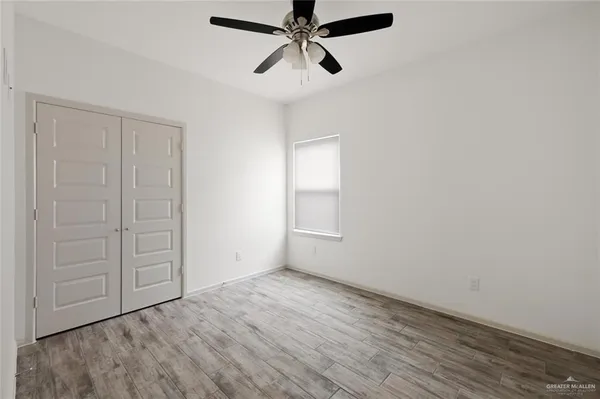 an empty room with closet and windows
