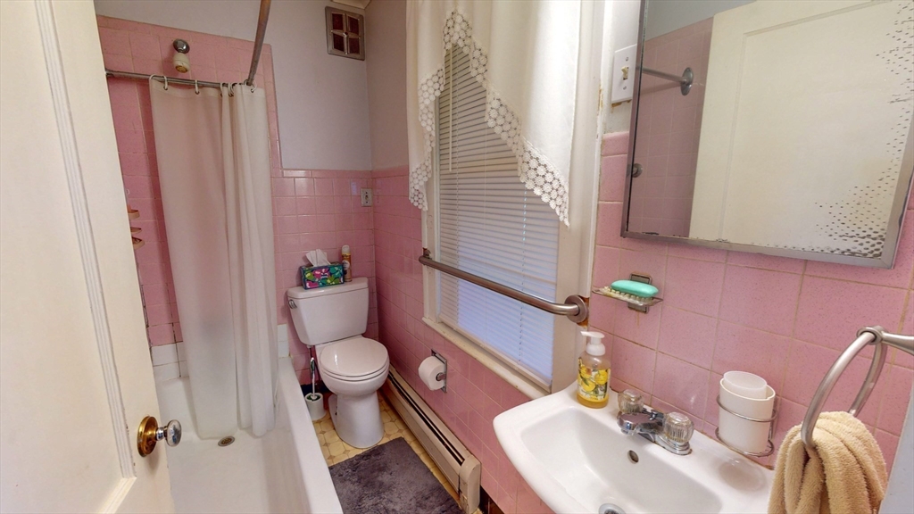 99 Lyons Street Springfield, MA 01151 - Photo 17 of 41 a bathroom with a sink a toilet and shower curtain