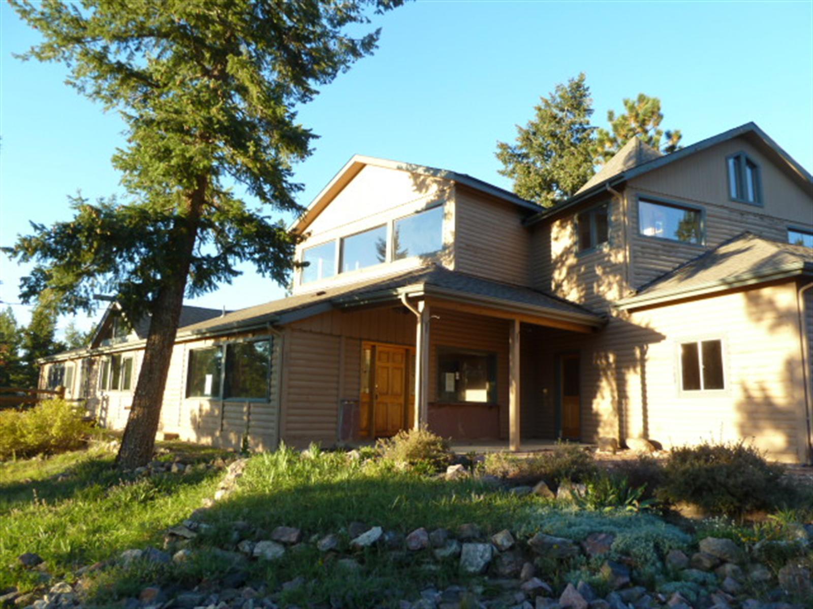 a view of a house with brick walls and a large tree