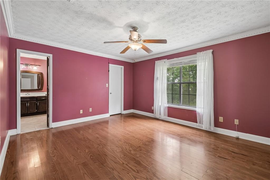 1318 Panhandle Way Hampton, GA 30228 - Photo 9 of 22 an empty room with wooden floor chandelier fan and windows