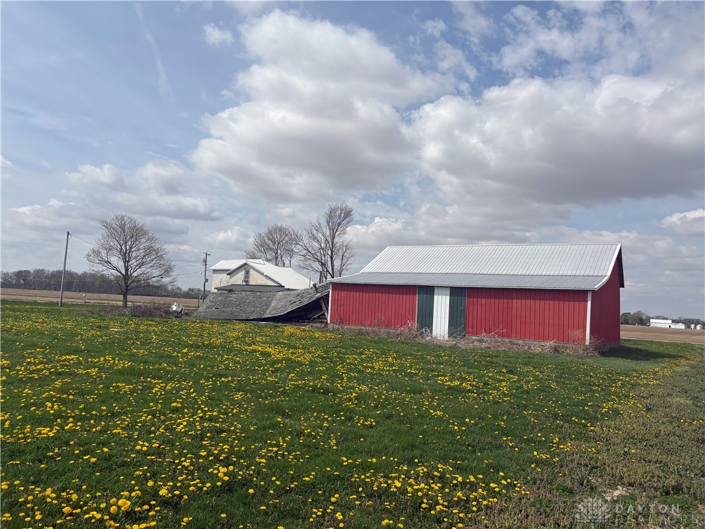9006 Oakes Road Arcanum, OH 45304 - Photo 9 of 29 This expansive rural property offers a vibrant green landscape with bright yellow wildflowers.