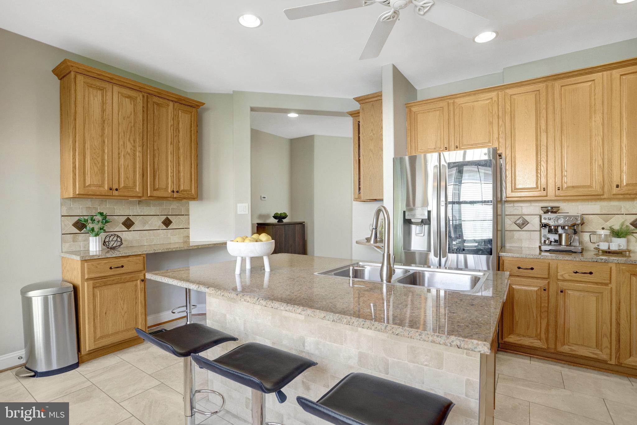 8552 Bauer Circle Springfield, VA 22152 - Photo 15 of 64 a kitchen with stainless steel appliances granite countertop a stove a sink a dining table and chairs