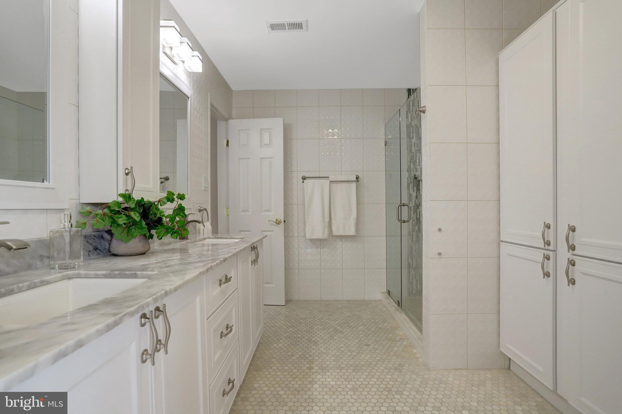 8552 Bauer Circle Springfield, VA 22152 - Photo 34 of 64 a bathroom with a granite countertop sink a mirror and a shower